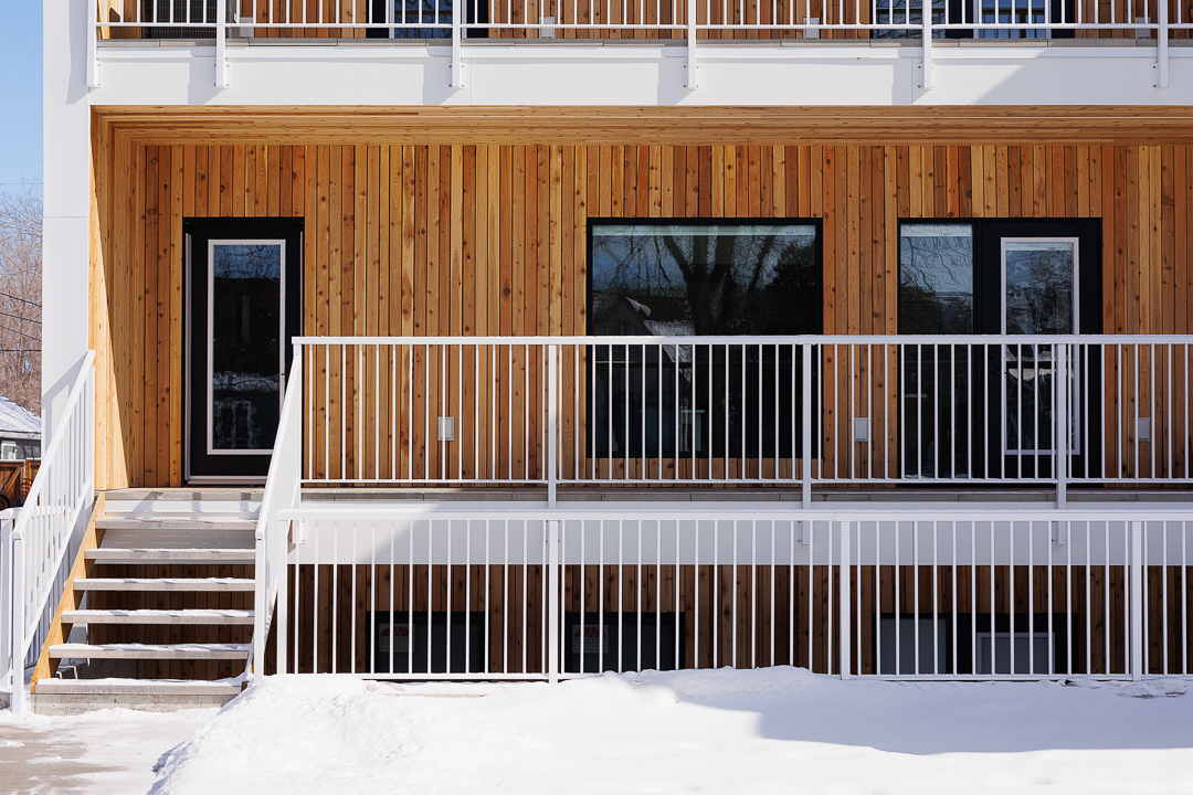 Cedar-clad exterior detail with white railing